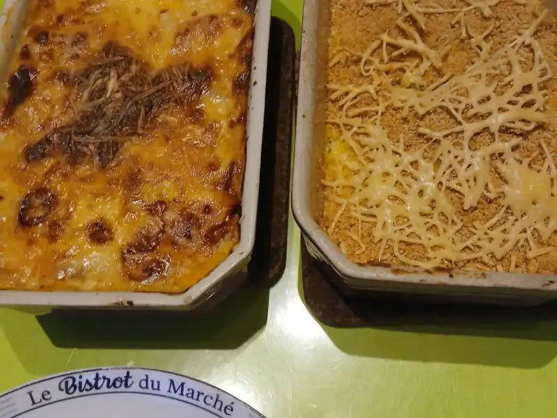 Złociste pory zapiekane i domowe puree zapiekane z bułką tartą w dwóch naczyniach na zielonym stole